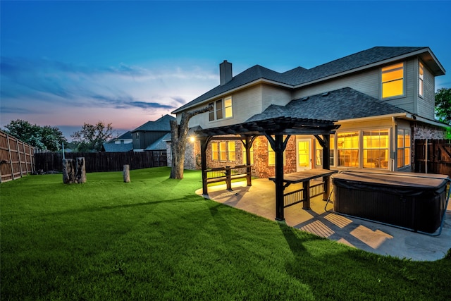 back house at dusk with a pergola, a patio area, a yard, and a hot tub