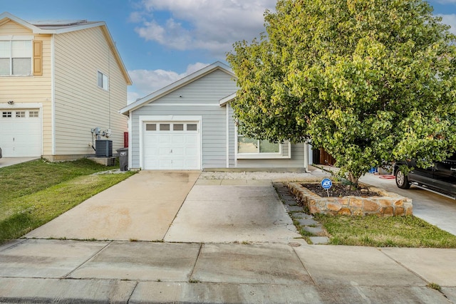 view of front of property with a garage, central air condition unit, and a front yard