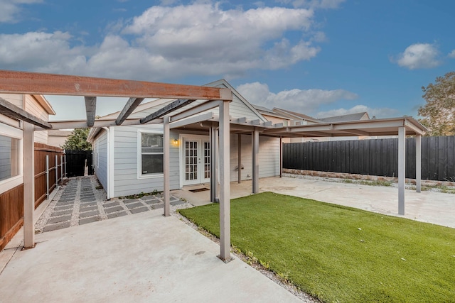 rear view of property with a lawn, french doors, and a patio