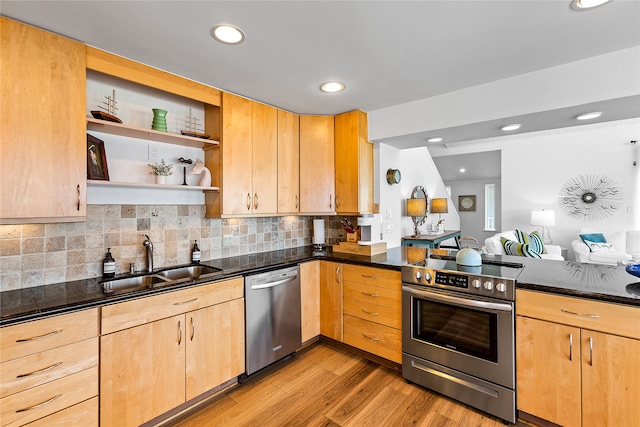 kitchen with appliances with stainless steel finishes, light hardwood / wood-style floors, tasteful backsplash, dark stone countertops, and sink