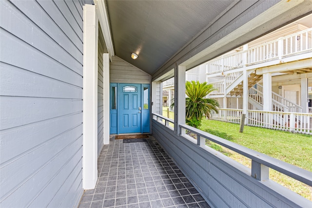 doorway to property with a lawn and covered porch