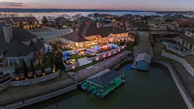 aerial view at dusk featuring a water view