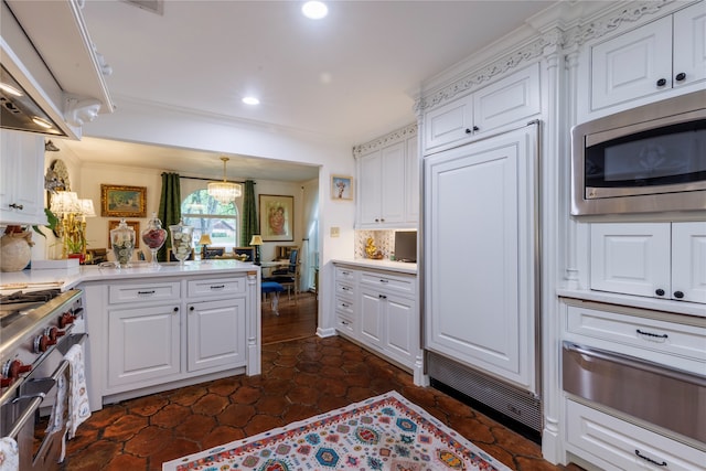 kitchen featuring ventilation hood, crown molding, pendant lighting, white cabinetry, and appliances with stainless steel finishes