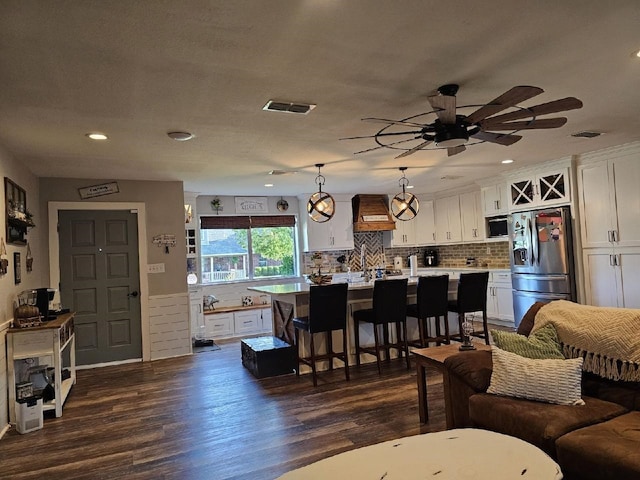 living room featuring ceiling fan and dark wood-type flooring