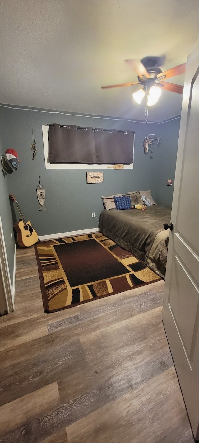 unfurnished bedroom featuring ceiling fan, hardwood / wood-style flooring, and a textured ceiling