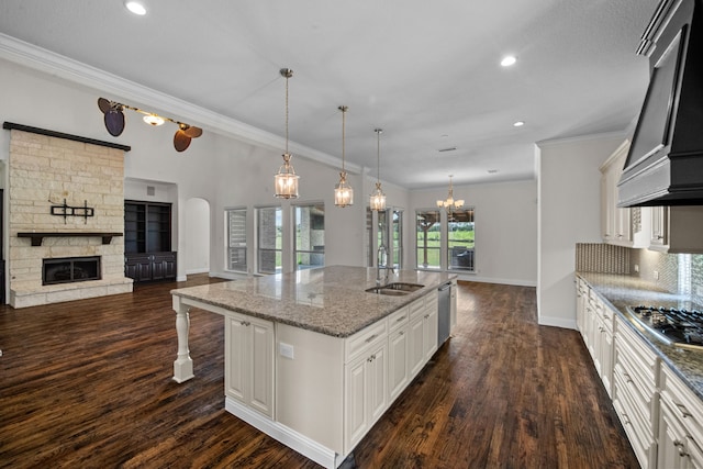 kitchen featuring dark hardwood / wood-style floors, a stone fireplace, custom range hood, and white cabinetry