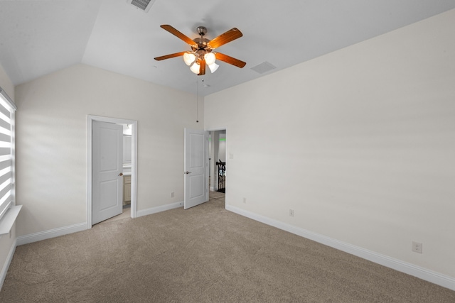 unfurnished bedroom featuring connected bathroom, carpet flooring, ceiling fan, and vaulted ceiling