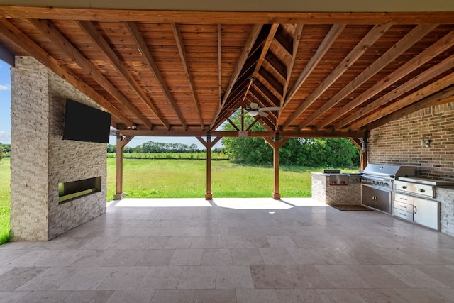 view of terrace with exterior kitchen and a grill