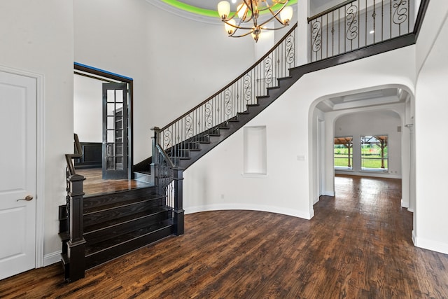 entrance foyer featuring a high ceiling, dark wood-type flooring, and an inviting chandelier