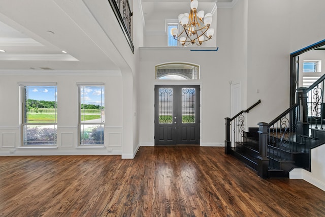 entrance foyer with a notable chandelier, french doors, a tray ceiling, and dark hardwood / wood-style floors