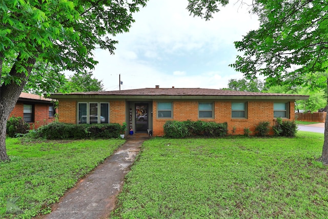 ranch-style home with brick siding and a front lawn