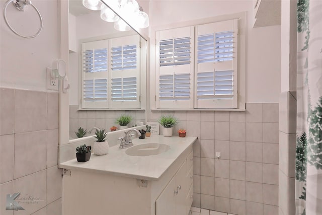 bathroom featuring vanity, a wealth of natural light, and tile walls