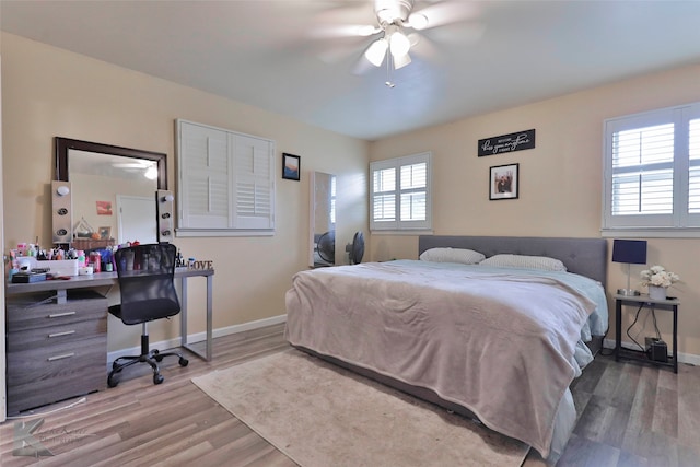 bedroom featuring multiple windows, ceiling fan, and wood-type flooring