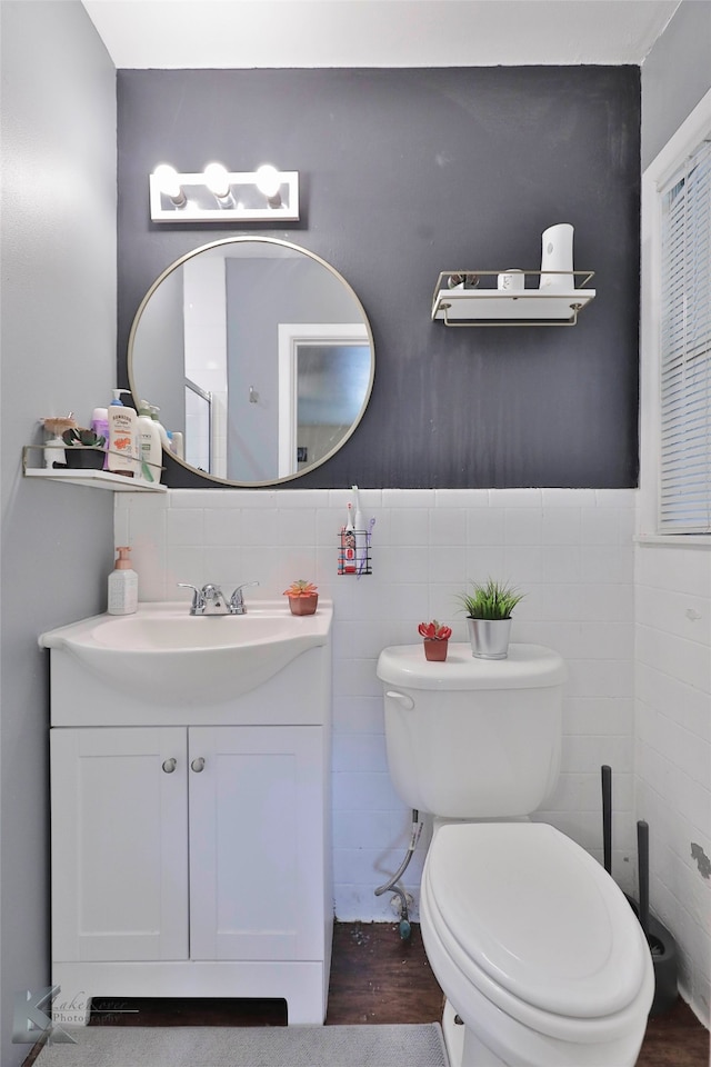 bathroom featuring hardwood / wood-style floors, vanity, toilet, and tile walls