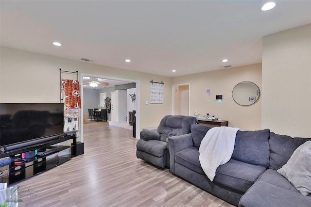 living room with ceiling fan and light wood-type flooring