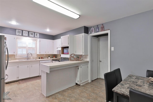 kitchen featuring white cabinetry, sink, kitchen peninsula, decorative backsplash, and appliances with stainless steel finishes