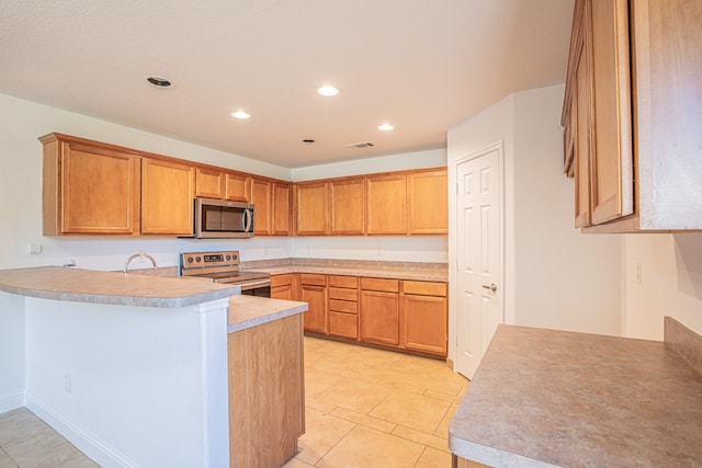 kitchen featuring light tile patterned flooring, kitchen peninsula, stainless steel appliances, and sink