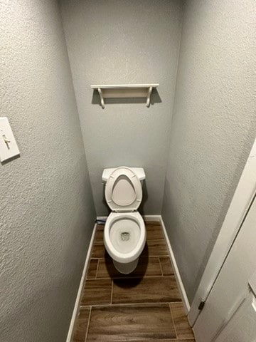 bathroom with wood-type flooring and toilet