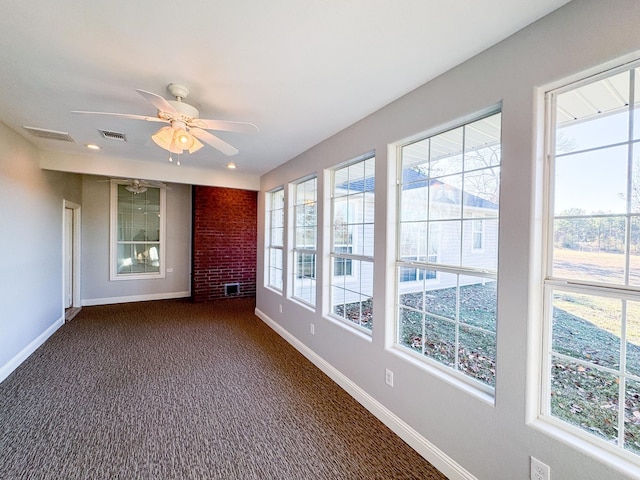 carpeted empty room with a wealth of natural light and ceiling fan