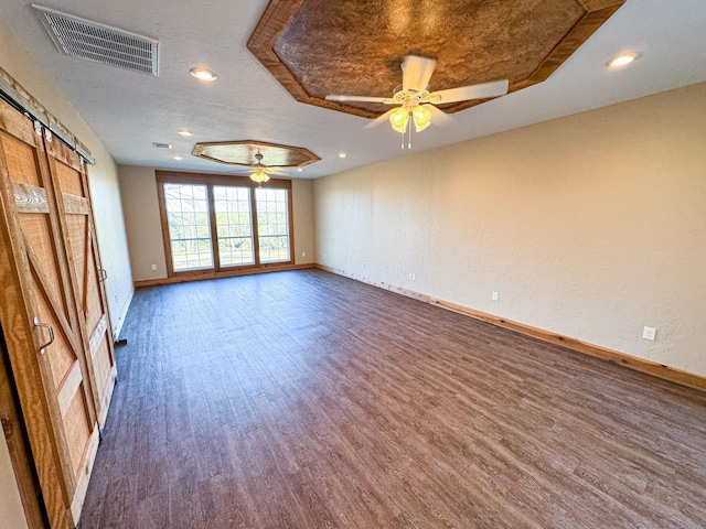 spare room with a raised ceiling, ceiling fan, and hardwood / wood-style flooring