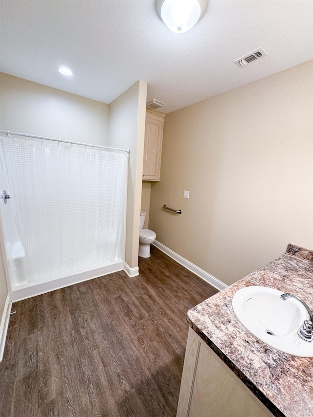 bathroom featuring wood-type flooring, vanity, and toilet