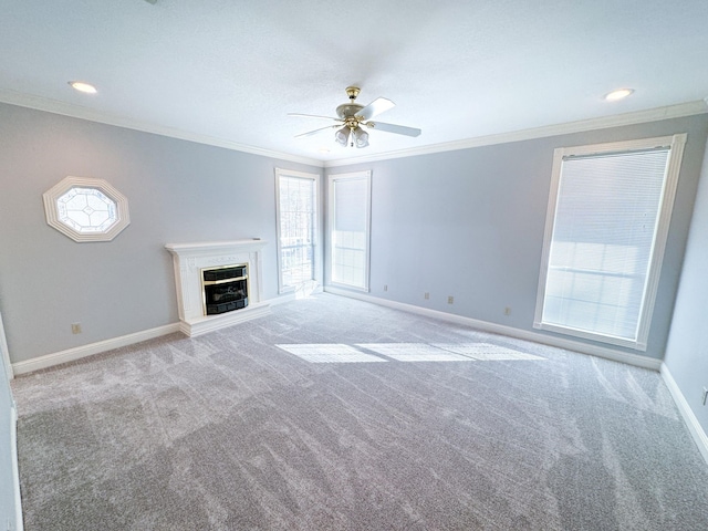 unfurnished living room with carpet, ceiling fan, and crown molding