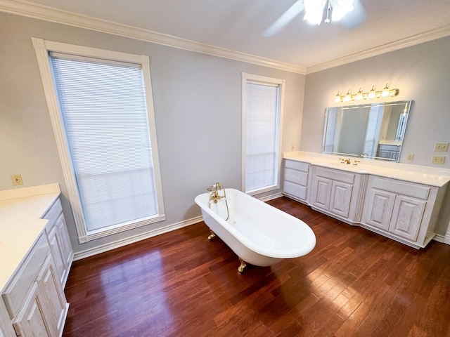 bathroom with ceiling fan, a washtub, wood-type flooring, vanity, and ornamental molding