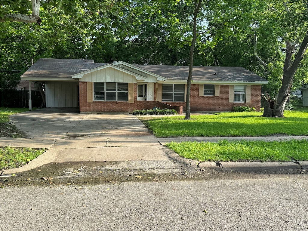 single story home featuring a front lawn and a carport