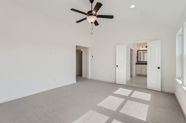 unfurnished bedroom featuring light colored carpet, connected bathroom, and ceiling fan