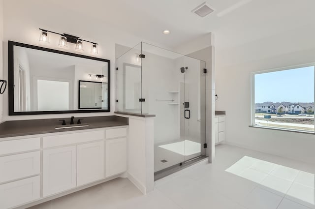 bathroom with a shower with door, tile patterned flooring, and vanity