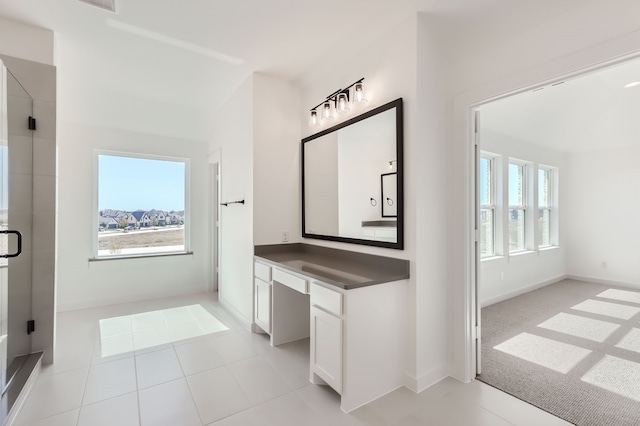 bathroom featuring vanity, a shower with door, tile patterned flooring, and a wealth of natural light