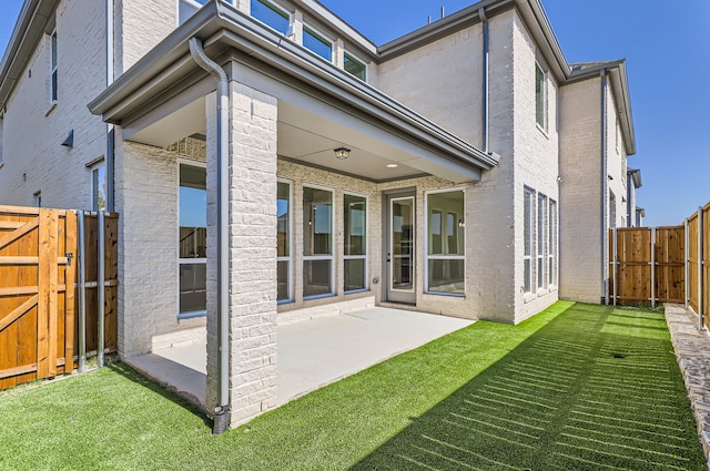 rear view of property featuring a patio area and a lawn