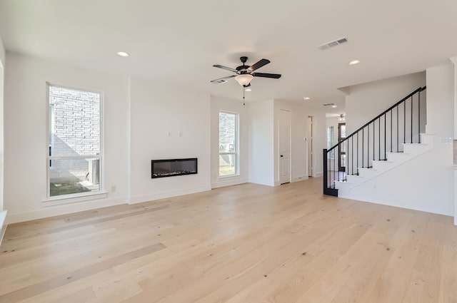 unfurnished living room featuring light hardwood / wood-style flooring, a healthy amount of sunlight, and ceiling fan