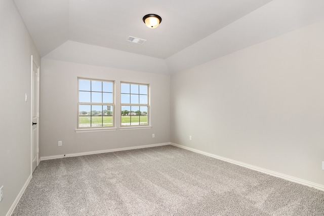 carpeted spare room featuring vaulted ceiling