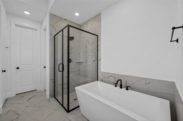 bathroom featuring plus walk in shower and tile walls