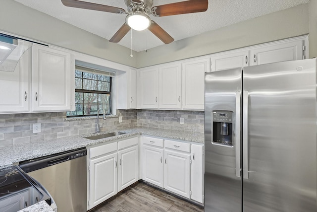 kitchen featuring appliances with stainless steel finishes, ceiling fan, white cabinets, sink, and hardwood / wood-style floors