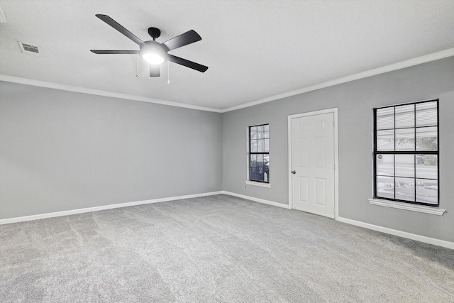 spare room featuring carpet floors, ceiling fan, and crown molding