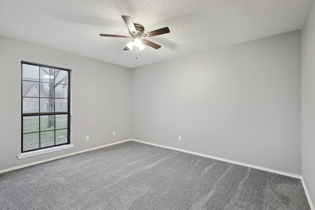 empty room with dark carpet, ceiling fan, and a textured ceiling