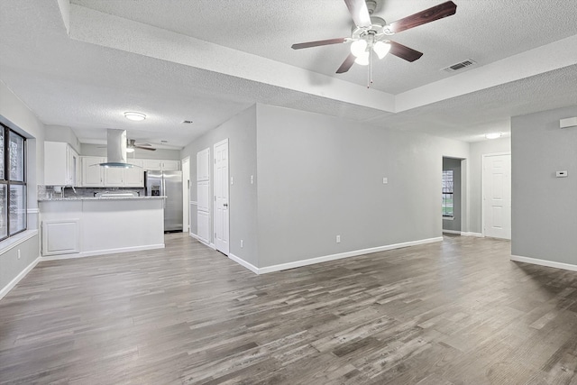 interior space featuring wood-type flooring, ceiling fan, and a textured ceiling