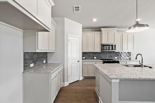 kitchen with white cabinetry, light stone countertops, sink, pendant lighting, and range with gas stovetop