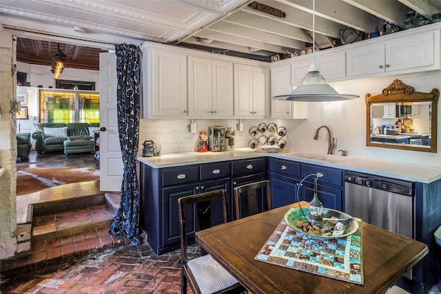 kitchen with stainless steel appliances, light countertops, a sink, and white cabinetry