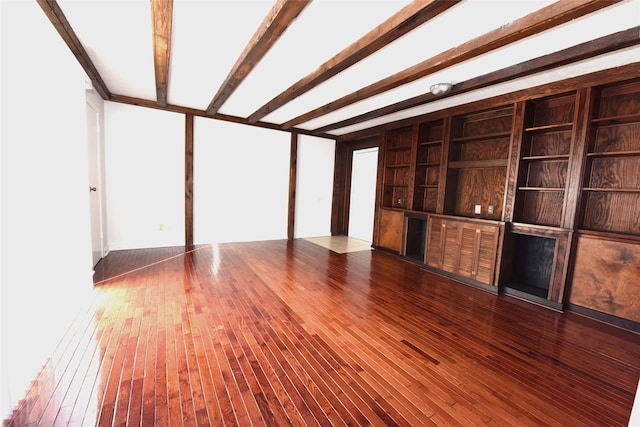 unfurnished living room featuring wood-type flooring and beam ceiling