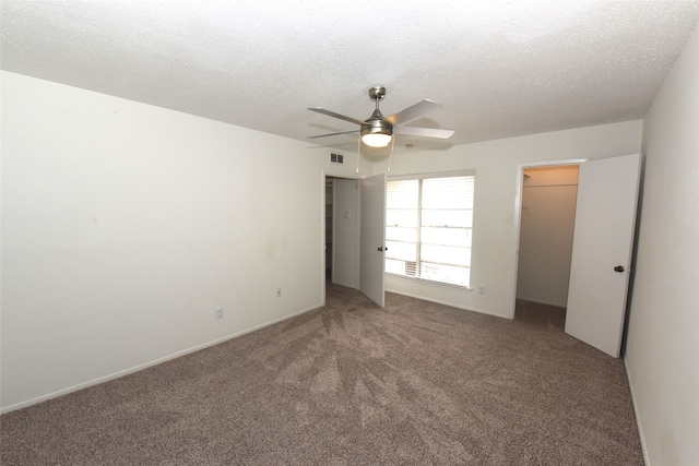 unfurnished bedroom with a closet, a textured ceiling, ceiling fan, and carpet floors