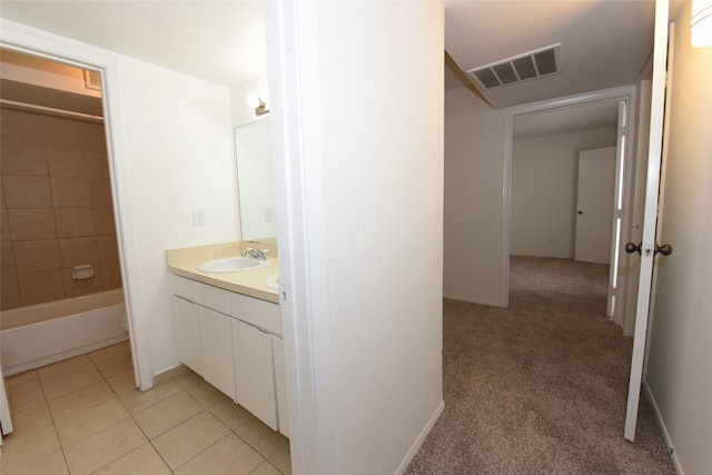 full bathroom with tiled shower / bath combo, toilet, tile floors, and vanity with extensive cabinet space