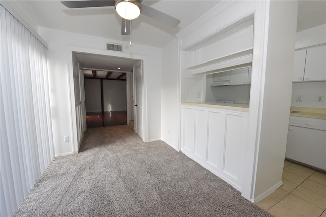 empty room featuring ceiling fan and light carpet