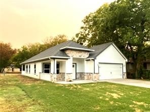 view of front of house featuring a garage and a lawn