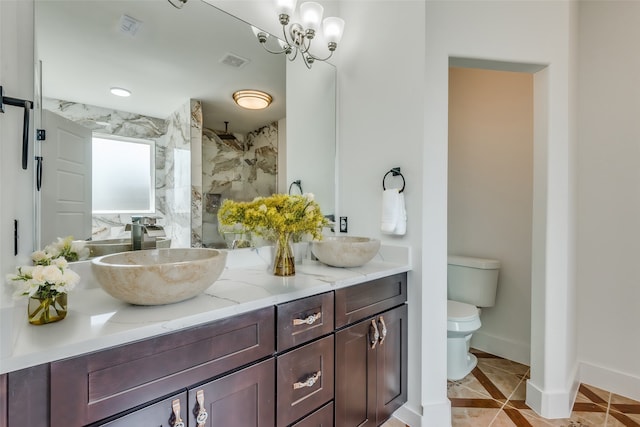 bathroom with vanity, tile patterned flooring, toilet, tiled shower, and a chandelier