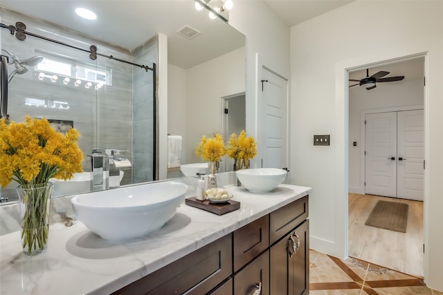 bathroom with ceiling fan, walk in shower, and vanity