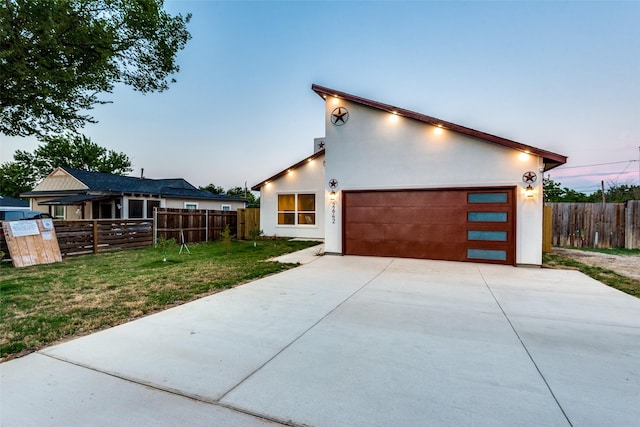 contemporary home featuring a garage and a yard