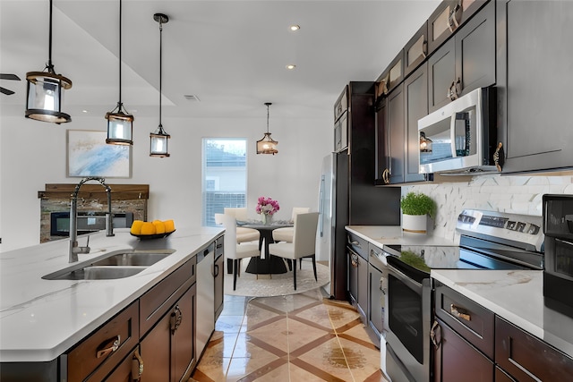 kitchen with decorative light fixtures, sink, dark brown cabinetry, and stainless steel appliances